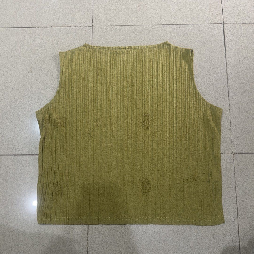 Issey Ins Pleated Top (Category: Sleeveless) located in Quezon City. Submitted by outyougoph (Listing ID 1469600242, Image 1). Description: - Color: Olive green - Texture: Ribbed with vertical pleats - Design: Wide neckline, sleeveless, straight hem - Condition: Pre-loved with several noticeable dark stains scattered on the front - Style: Casual basic tank top.