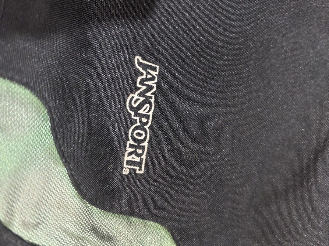 JanSport Messenger Bag Black Green (Category: Sling Bags) located in Manila. Submitted by jsu2026 (Listing ID 1469694329, Image 2). Description: - Brand: JanSport - Colorway: Black and Green - Condition: Clean interior with tag attached - Strap: Adjustable shoulder strap for custom comfort - Storage: Large front flap with zipper, spacious main compartment, interior organizer pockets, and mesh side pockets - Material: Durable fabric construction b