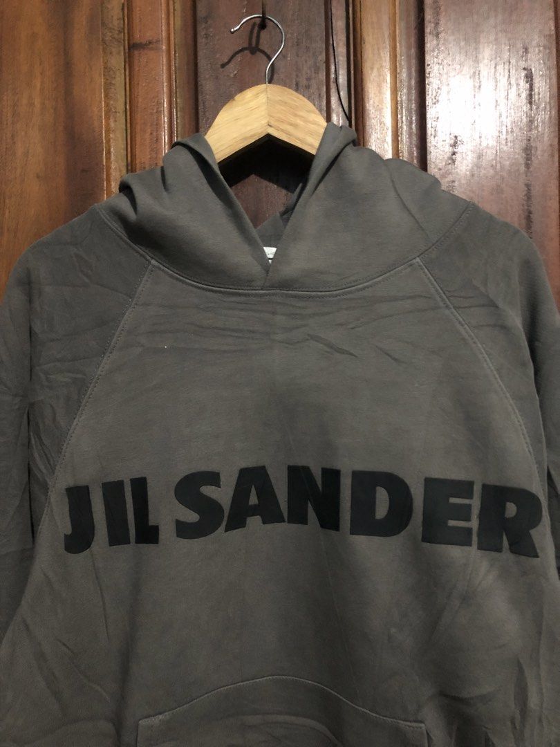 Jil Sander Dark Grey Logo Hoodie (Category: Hoodies) located in Quezon City. Submitted by yeahsource222 (Listing ID 1469745039, Image 2). Description: - Authentic Jil Sander heavyweight hoodie in dark grey - Bold black branding across the front - Iconic white brand label stitched on the back of the hood - Comfortable pullover style with a front kangaroo pocket - Relaxed fit with raglan sleeves and ribbed cuffs/hem.