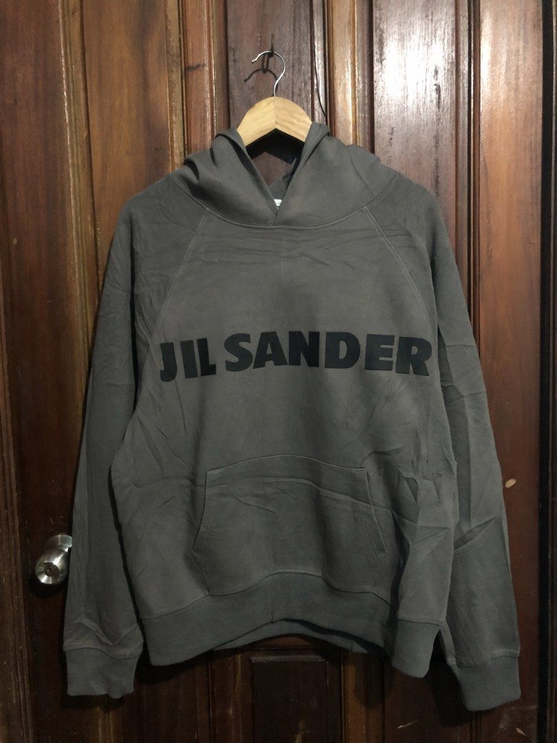 Jil Sander Dark Grey Logo Hoodie (Category: Hoodies) located in Quezon City. Submitted by yeahsource222 (Listing ID 1469745039, Image 1). Description: - Authentic Jil Sander heavyweight hoodie in dark grey - Bold black branding across the front - Iconic white brand label stitched on the back of the hood - Comfortable pullover style with a front kangaroo pocket - Relaxed fit with raglan sleeves and ribbed cuffs/hem.