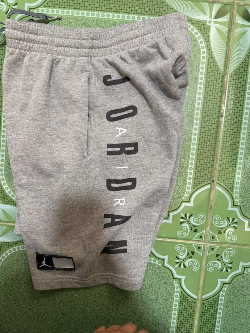 Jordan Grey Sweatshorts with Wings Logo (Category: Shorts) located in Vinzons. Submitted by pongsthrift (Listing ID 1469677690, Image 1). Description: - Authentic Jordan grey cotton fleece shorts - Comfortable elastic waistband with dark grey adjustable drawstring - Bold vertical Jordan branding on the left leg - Nike Swoosh and iconic Air Jordan wings logo on the right leg - Woven jock tag patch near the hem for added detail - Casual and versati