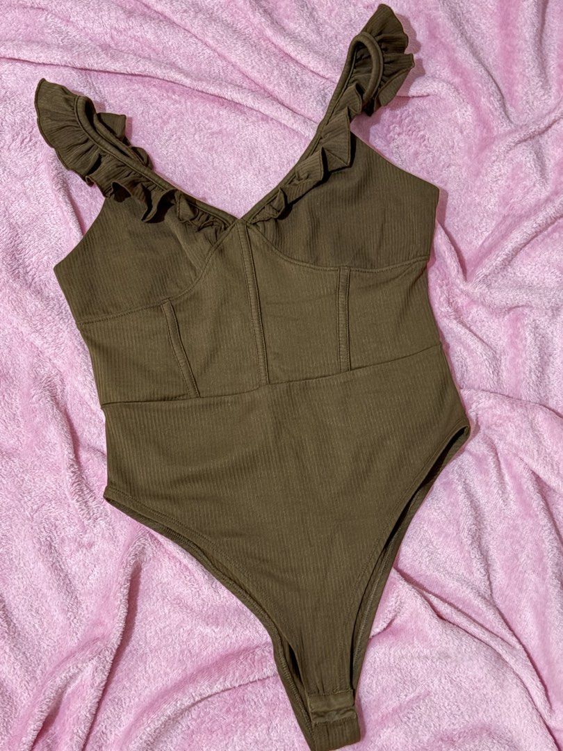 Just G Brown Ribbed Bodysuit Size M (Category: Sleeveless) located in Nagcarlan. Submitted by nkkva (Listing ID 1469690094, Image 1). Description: - Brand: Just G - Size: Medium - Color: Brown - Material: Stretchy ribbed fabric - Details: Ruffle straps, front corset seams, V-neck, snap button closure at the bottom - Condition: Great basic piece for layering or standalone wear.