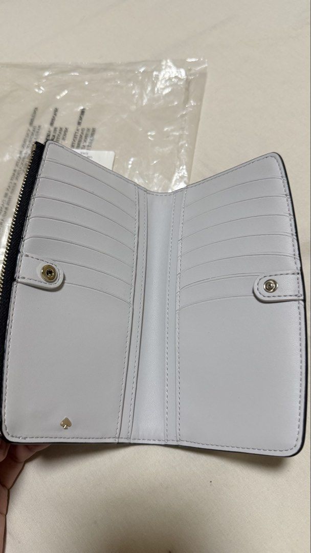 Kate Spade Knott Pebbled Leather Zip Slim Wallet Black (Category: Wallets & Card holders) located in Makati City. Submitted by mbcab (Listing ID 1469695617, Image 2). Description: Kate Spade Knott pebbled leather zip slim wallet in black. Model K5613. Genuine pebble leather construction with gold-tone hardware and spade logo. Interior features multiple card slots and snap closure compartments. Brand new with tags and original packaging including 