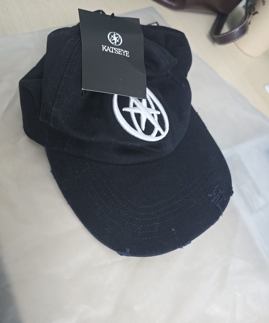 Katseye Distressed Baseball Cap Black Official Merch (Category: Caps & Hats) located in Talisay. Submitted by stormborn2040 (Listing ID 1469697567, Image 1). Description: - Official Katseye merchandise - Color: Black distressed with white embroidered front logo - Material: 100% cotton, made in Bangladesh - Closure: Adjustable strapback for a custom fit - Condition: Brand new with original tags attached, kept in plastic packaging.