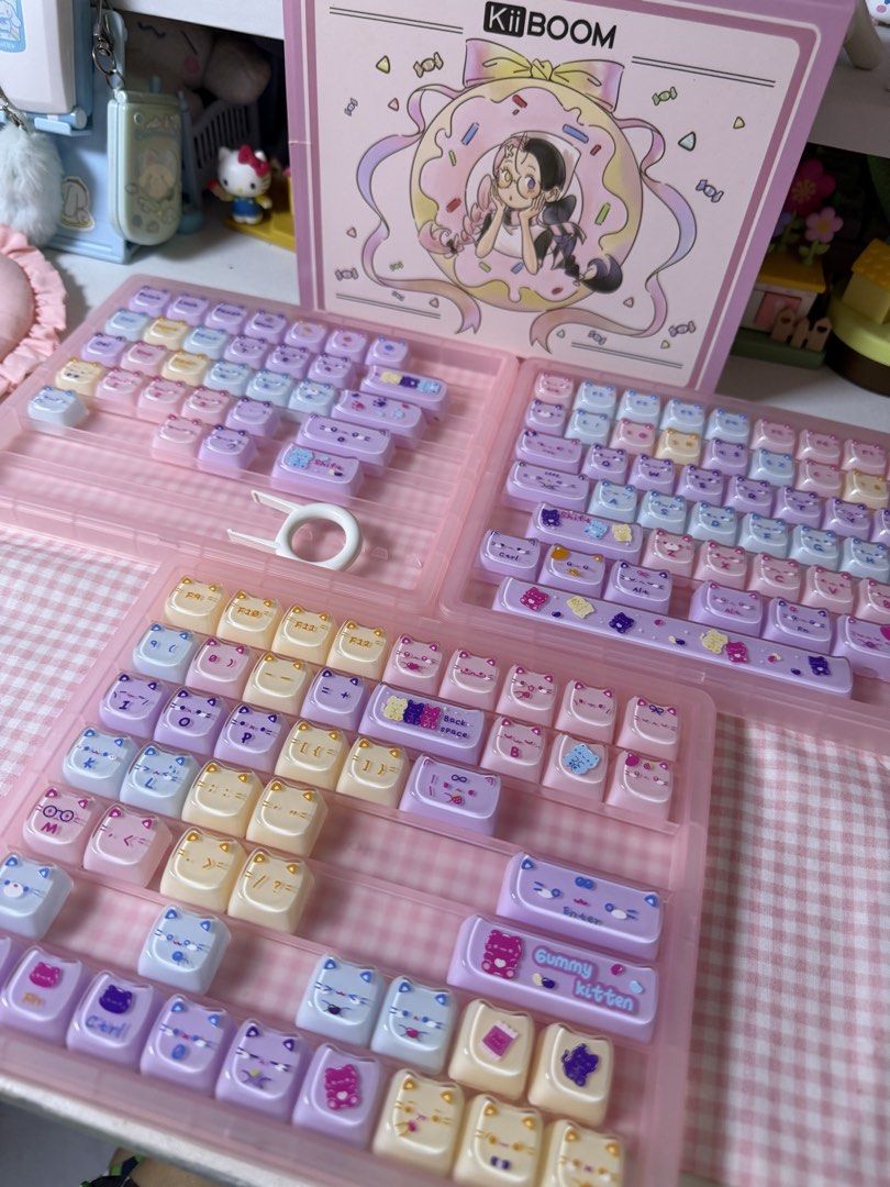 KiiBOOM Gummy Meow Pudding Keycaps Set (Category: Computer Keyboard) located in Mabalacat. Submitted by strawbearytelle (Listing ID 1469601569, Image 2). Description: - Brand: KiiBOOM - Model: Gummy Kitten Mechanical Keyboard Keycap Set - Design: Pastel pink, purple, blue, and cream colorway with cute cat faces, gummy bears, and candy graphics - Inclusions: Multiple layout options, novelty keys, original pink storage cases, and keycap puller tool