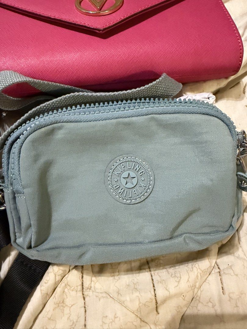 Kipling light blue crossbody bag (Category: Cross-body Bags) located in Las Pinas. Submitted by ishein (Listing ID 1469663496, Image 1). Description: - Authentic Kipling crossbody bag in a chic light blue shade - Crafted from durable, lightweight crinkle nylon - Compact size with a secure zippered top closure - Features the iconic round rubber logo patch on the front - Comes with an adjustable, matching light blue strap - Ideal daily grab for you