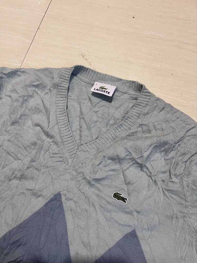 Lacoste Argyle V-Neck Sweater Blue Size 5 (Category: Longsleeves) located in Zamboanga. Submitted by safe.haimer (Listing ID 1469684862, Image 2). Description: - Brand: Lacoste - Design: Blue argyle gradient pattern (light blue to dark navy) - Material: 100% wool - Size: Tagged Size 5 (fits Korean Size 105 / XL) - Features: V-neck, long sleeves, ribbed cuffs and hem - Condition: Excellent, clean inner label and intact tags.