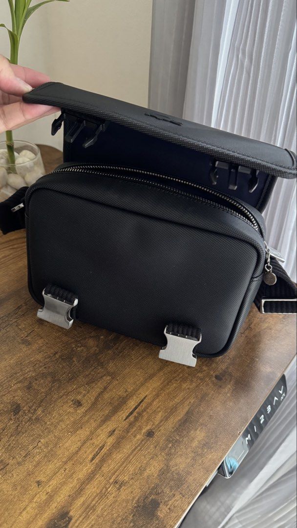 Lacoste Black Messenger / Crossbody Bag (Category: Sling Bags) located in Manila. Submitted by spicybean (Listing ID 1469703134, Image 3). Description: Lacoste Black Messenger Bag • Authentic Lacoste • Very good condition • Black textured exterior • Adjustable crossbody strap • Flap closure with two silver-tone buckles • Secure zippered main compartment • Interior pockets for essentials • Subtle embroidered Lacoste crocodile logo • Clean inside a