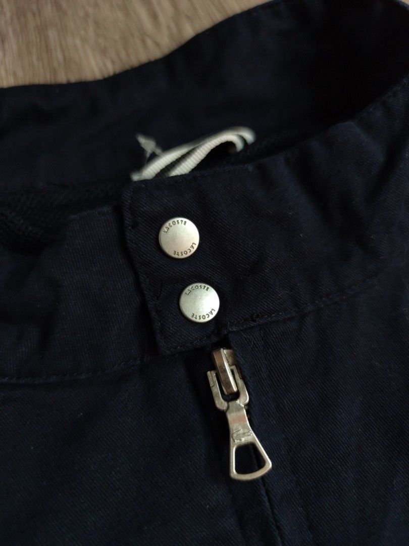 Lacoste Harrington Navy Blue Jacket BH3921 (Category: Coats, Jackets and Outerwear) located in Pasig City. Submitted by vintage.thrifttph (Listing ID 1469651752, Image 3). Description: - Brand: Lacoste - Style Number: BH3921 - Condition: Used 9/10 condition - Color: Solid Navy - Size: 23 width 25 length (boxy fit) - Details: Full zip front, mock collar with snap buttons, comfortable mesh lining, ribbed cuffs and hem - Features the iconic Lacoste 