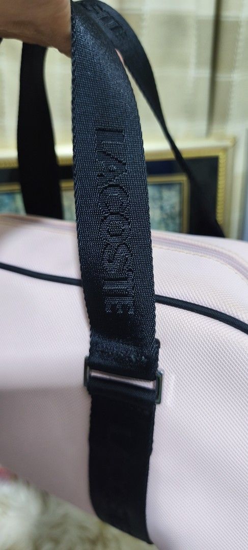 Lacoste Pink Barrel Bag Duffel Bag (Category: Luxury Bags & Wallets) located in Manila. Submitted by shawn0320_fish (Listing ID 1469624417, Image 3). Description: - Brand: Lacoste - Style: Barrel bag - Color: Pink with black accents - Straps: Black woven straps with bold LACOSTE lettering - Closure: Smooth top zipper with contrasting stitching - Structure: Structured design with black piping details - Size: Approximately 11 inches across.