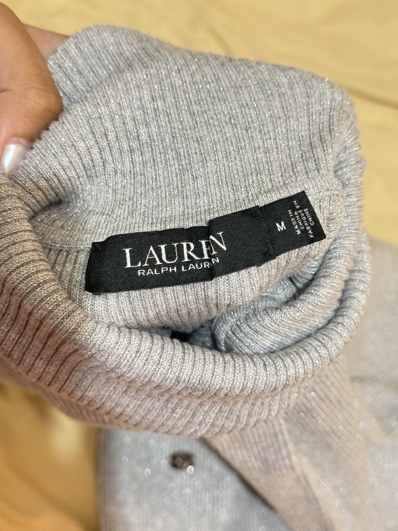 Ralph Lauren Silver Metallic Turtleneck Sweater Size M (Category: Longsleeves) located in Mandaluyong City. Submitted by stylececilia.ph (Listing ID 1469735721, Image 2). Description: - Brand: Lauren Ralph Lauren - Size: M - Color: Silver with sparkly metallic thread - Material: Soft and stretchy cotton blend - Design: Ribbed knit texture, long sleeves, and turtleneck collar - Detail: Signature metal RL logo plaque near the hem - Condition: Brand