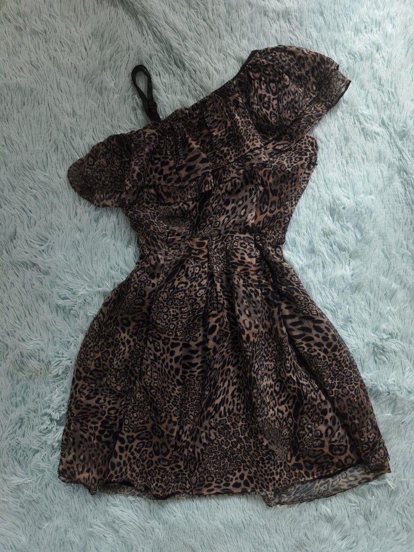 Leopard Print One Shoulder Ruffle Chiffon Dress (Category: Dresses) located in Quezon City. Submitted by alluring.avenue (Listing ID 1469600413, Image 1). Description: - Style: Leopard print mini dress with an asymmetrical one-shoulder design and extra strap detail - Design: Layered ruffle overlay across the top with a fitted waist and flared, pleated skirt - Material: Lightweight chiffon fabric with an all-over animal print - Occasion: Perfect f