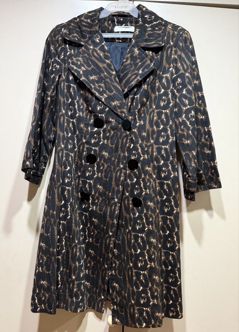 Leopard Print Trench Coat (Category: Coats, Jackets and Outerwear) located in Muntinlupa City. Submitted by caroucella (Listing ID 1469634537, Image 1). Description: Leopard print trench coat with black buttons down the front. Lapel collar and structured shoulders. Back includes a decorative half-belt flap detail with two black buttons. Dark lining inside. Catchy animal print pattern all over. Super stylish.