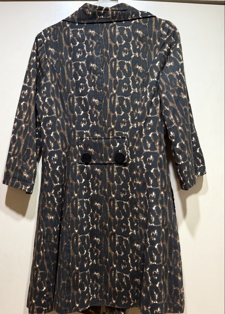 Leopard Print Trench Coat (Category: Coats, Jackets and Outerwear) located in Muntinlupa City. Submitted by caroucella (Listing ID 1469634537, Image 3). Description: Leopard print trench coat with black buttons down the front. Lapel collar and structured shoulders. Back includes a decorative half-belt flap detail with two black buttons. Dark lining inside. Catchy animal print pattern all over. Super stylish.