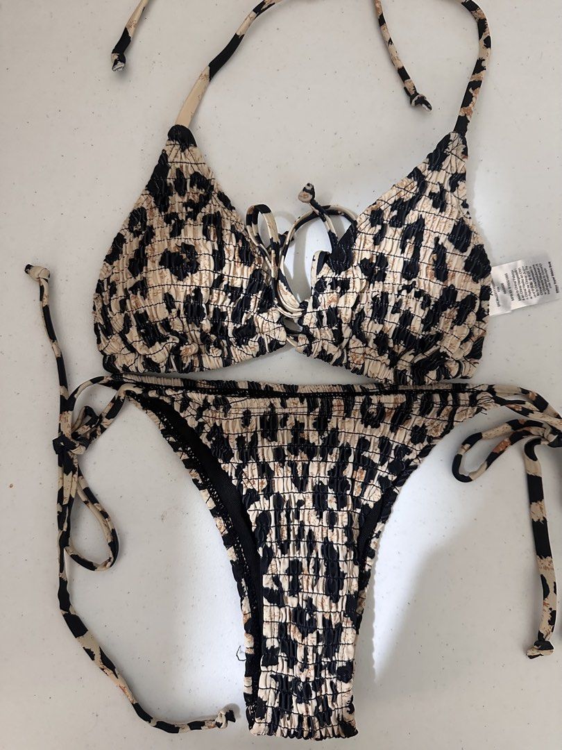 Leopard Print Triangle Bikini Set (Category: Bikinis & Swimsuits) located in Pasig City. Submitted by prelovedbysco (Listing ID 1469691015, Image 1). Description: - Brand: Shein - Condition: Brand new with tags (never worn) - Size: XS, fits 32-34A cup - Pattern/Texture: Leopard print with all-over smocked fabric - Design: Triangle top with string ties, matching side-tie bottoms, and black contrast trim RFS: used once for beach trip, only bought t