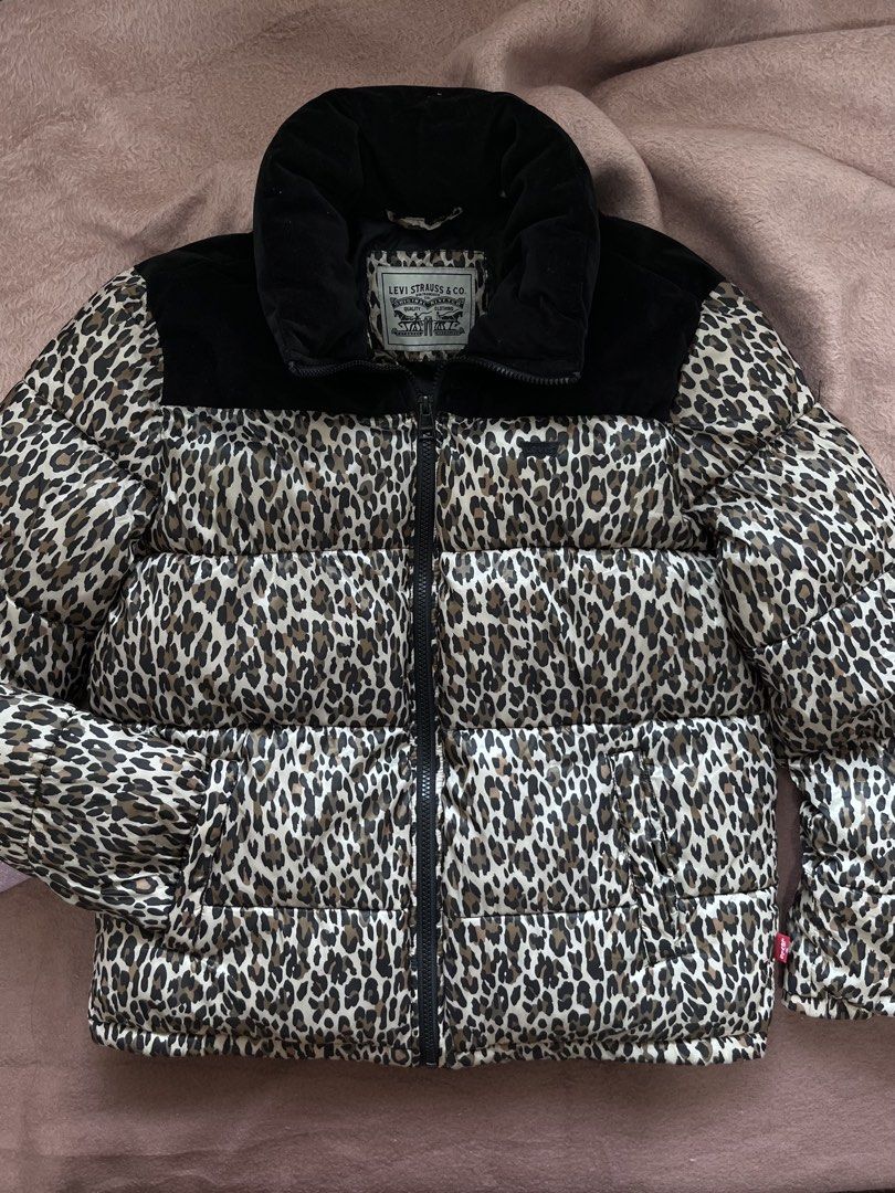 Levi's Leopard Print Puffer Jacket (Category: Coats, Jackets and Outerwear) located in Mandaluyong City. Submitted by chienneclassique (Listing ID 1469688760, Image 2). Description: - Brand: Levi's - Design: Bold all-over leopard print with contrasting black velvet collar and yoke panel - Closure: Full front zip with dual zip pulls and high stand-up collar for extra warmth - Details: Signature Levi's logo patch on the chest and classic red tab on