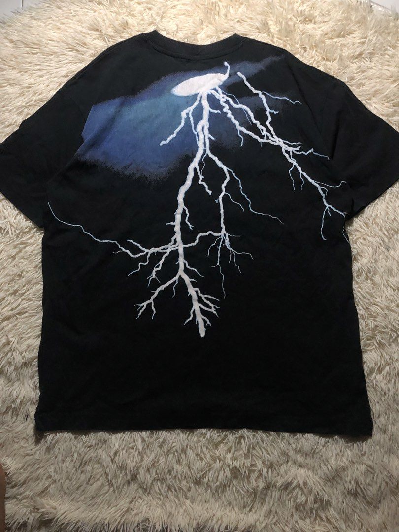 Lightning Graphic Shirt Distressed (Category: Tshirts & Polo Shirts ) located in Maria Aurora. Submitted by kylerikathriftshop101010 (Listing ID 1469718090, Image 1). Description: 24 by 29 distressing good quality yung tela - Color: Black - Style: Short sleeve crew neck t-shirt with a standard straight hem - Design: Large white and blue lightning bolt graphic on the back - Detail: Small embroidered cloud and lightning logo patch near the bottom h
