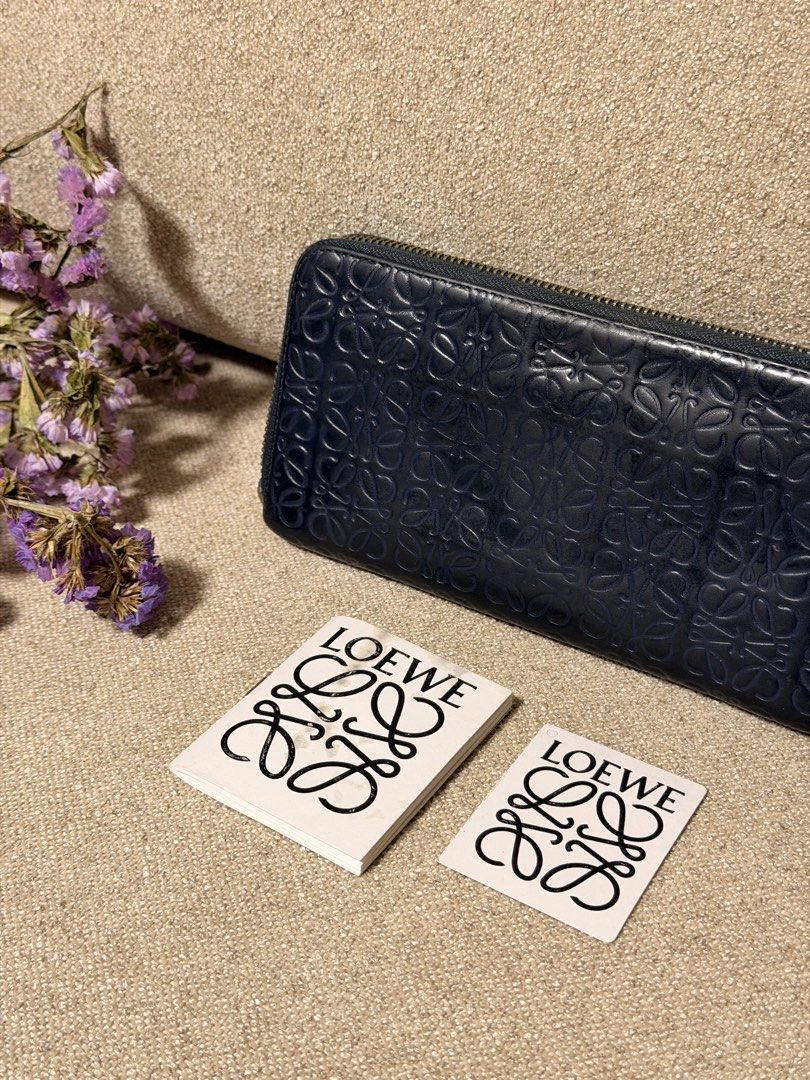 Loewe Anagram Zip Around Wallet (Category: Luxury Bags & Wallets) located in Manila. Submitted by monicagellerbing__ (Listing ID 1469705548, Image 2). Description: - Brand: Loewe - Color: Navy blue - Material: Premium leather with iconic debossed anagram pattern - Hardware: Gold-tone zip-around closure that runs smoothly - Interior: Card slots, slip pockets, and a zippered coin compartment - Origin: Made in Spain - Inclusions: Original cards and 