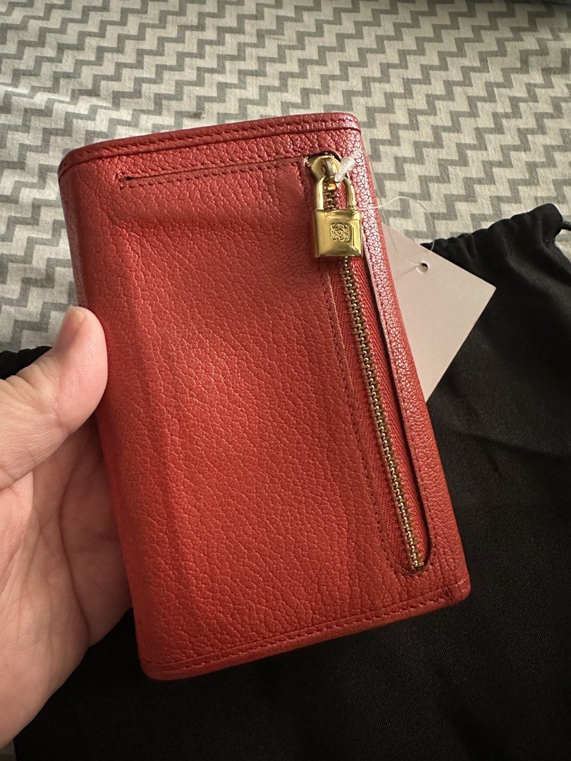 Loewe Red Leather Long Wallet with Lock Charm (Category: Wallets & Card holders) located in Antipolo. Submitted by prelovedcloseta (Listing ID 1469610856, Image 2). Description: - Brand: Loewe - Style: Long wallet / continental wallet - Color: Rich red with gold-tone hardware - Material: Premium textured leather with soft leather lining - Closure: Secure snap button closure - Interior: Multiple card slots and structured accordion compartments - E