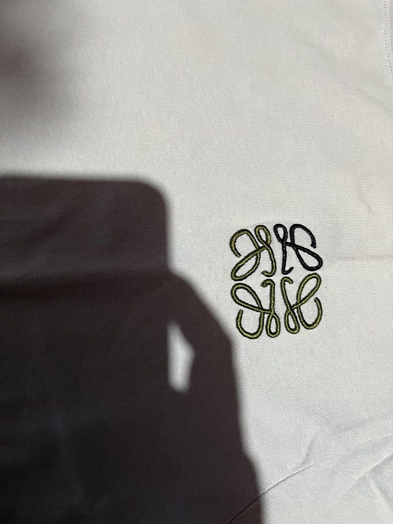 Loewe T-shirt with Anagram Logo (Category: Shirts) located in Cavite. Submitted by christianzuuu (Listing ID 1469739982, Image 3). Description: - Brand: Loewe - Color: Light grey - Material: 100% cotton - Details: Small embroidered Anagram logo on chest, crew neck, short sleeves, standard fit - Size/Measurements (Flat Lay): Length ~26.5 inches, Width ~21 inches - Condition: Clean overall, with a minor yellowish stain near the right shoulder area.