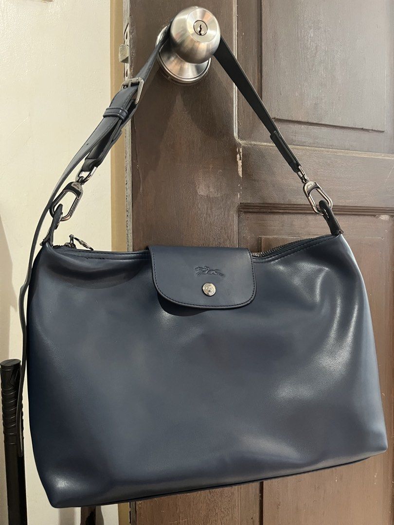 Longchamp Navy Leather Shoulder Bag (Category: Luxury Bags & Wallets) located in Mabalacat. Submitted by onlygrail.pamp (Listing ID 1469634277, Image 1). Description: - Brand: Longchamp - Color: Navy blue - Material: Premium leather - Closure: Secure top zip with branded metal pull - Front Detail: Embossed logo flap with snap button - Strap: Adjustable matching strap with silver-toned hardware rings - Condition: Sturdy construction, clean, and id
