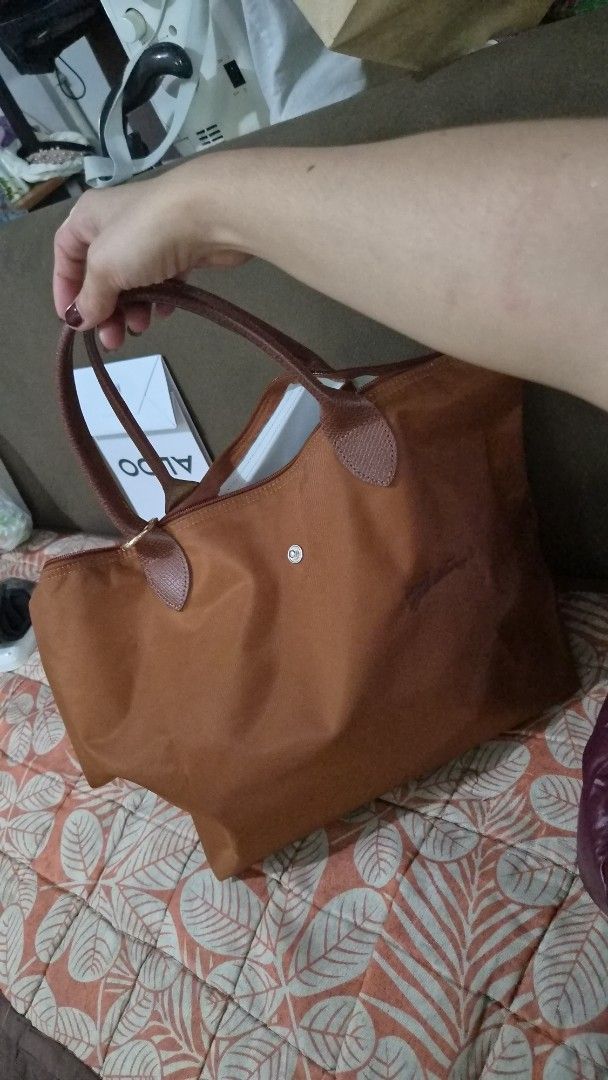 Longchamp Paris Brown Nylon Tote Bag medium short handle (Category: Luxury Bags & Wallets) located in Manila. Submitted by sereenity (Listing ID 1469611729, Image 1). Description: - Brand: Longchamp Paris - Color: Brown - Material: Durable nylon body with genuine leather handles and flap closure - Closure: Snap button and zipper - Style Number: 1623919504 (Made in China) - Interior: Roomy and spacious, perfect for daily use, work, or school - Con