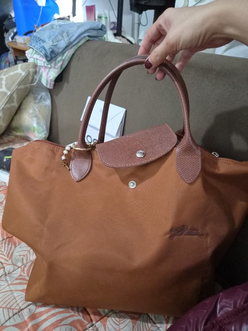 Longchamp Paris Brown Nylon Tote Bag medium short handle (Category: Luxury Bags & Wallets) located in Manila. Submitted by sereenity (Listing ID 1469611729, Image 2). Description: - Brand: Longchamp Paris - Color: Brown - Material: Durable nylon body with genuine leather handles and flap closure - Closure: Snap button and zipper - Style Number: 1623919504 (Made in China) - Interior: Roomy and spacious, perfect for daily use, work, or school - Con