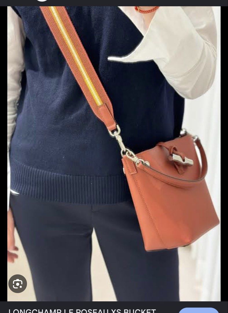 Authentic Longchamp XS Le Roseau Bucket Bag (Category: Luxury Bags & Wallets) located in Manila. Submitted by bagluxeph (Listing ID 1469712006, Image 3). Description: - Brand: Longchamp - Style: Compact bucket bag - Color: Warm cognac brown - Closure: Distinctive front bamboo toggle - Hardware: Silver-tone - Straps: Includes 2 interchangeable straps (short leather handle and wide rust/mustard striped canvas shoulder strap) - Size: Convenient for 