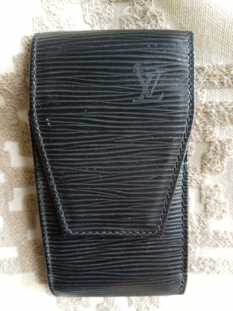 Louis Vuitton Epi Leather Cigarette Case Black (Category: Luxury Bags & Wallets) located in Las Pinas. Submitted by bettybellv (Listing ID 1469582406, Image 1). Description: - Authentic Louis Vuitton cigarette case crafted from signature black Epi leather - Features a textured finish with the iconic LV logo embossed on the front flap - Solid construction with durable, sturdy stitching along the sides - Interior stamped with Louis Vuitton Paris Ma