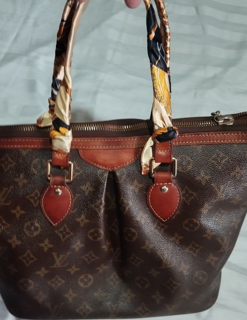 Louis Vuitton Monogram Canvas Handbag (Category: Tote Bags) located in Manila. Submitted by lene48 (Listing ID 1469579806, Image 1). Description: - Brown monogram canvas bag with matching leather trim and gold-tone hardware - Secure top zip closure for everyday peace of mind - Roomy interior ideal for daily essentials and work items - Handles beautifully wrapped in trendy patterned silk twill scarves - Features a chic hanging LV logo charm for an