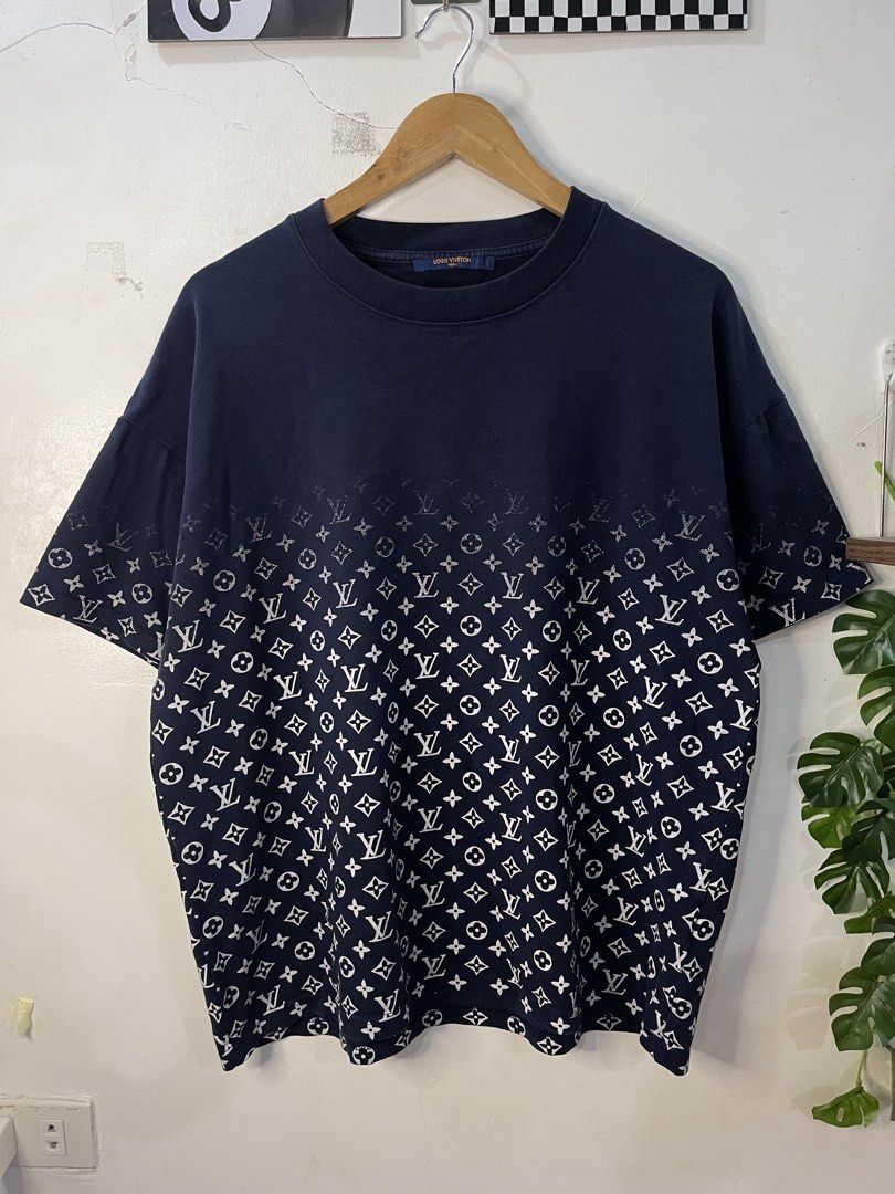Louis Vuitton Monogram Gradient Navy Blue T-shirt (Category: Tshirts & Polo Shirts ) located in Cabagan. Submitted by blessingma81004 (Listing ID 1469740807, Image 2). Description: Louis Vuitton navy blue t-shirt made in Italy - Features a stylish gradient monogram print fading toward the top - Tagged Size M, fits like a Large (Actual measurements: Width 24" x Length 27") - Detailed with a branded collar tag and rear leather patch - Note: Minimal