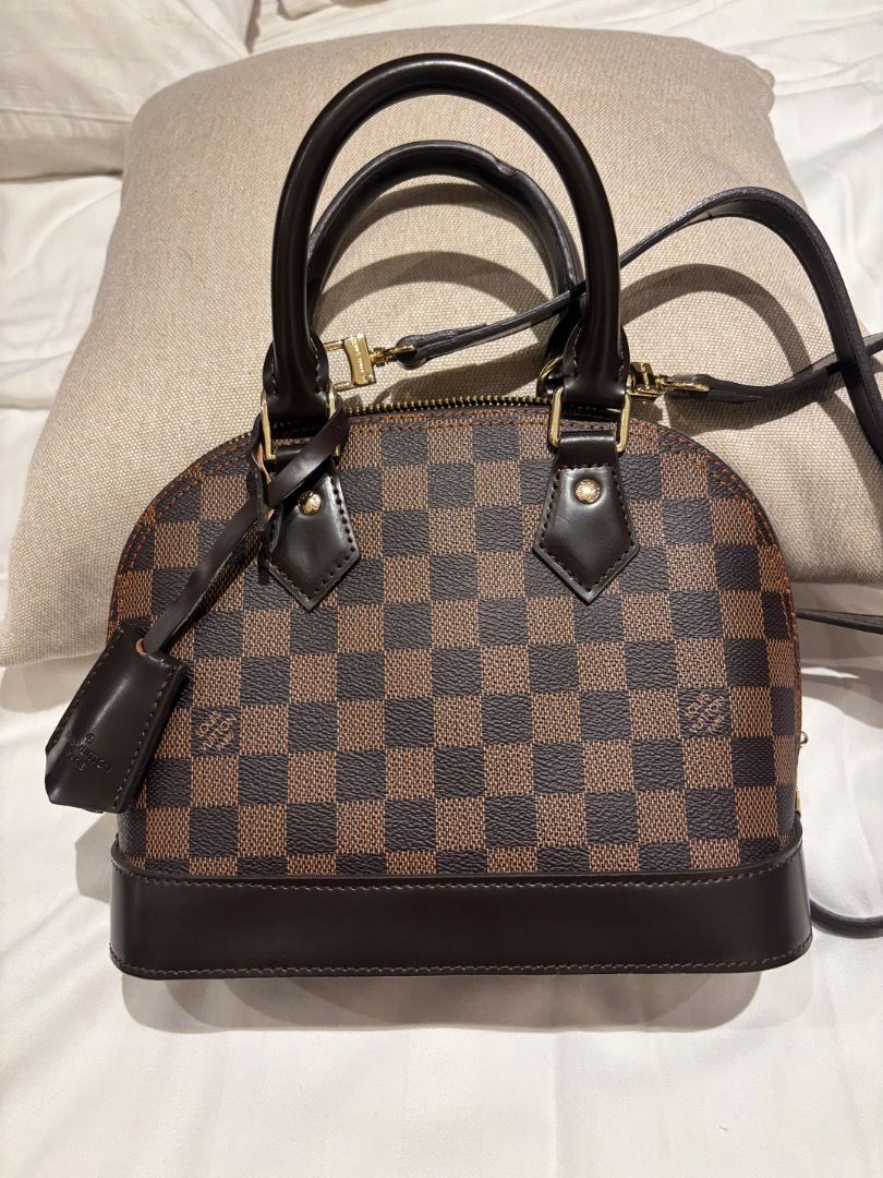 LV Damier Ebene Alma BB Bag (Category: Luxury Bags & Wallets) located in Cebu City. Submitted by bettzy77 (Listing ID 1469750427, Image 1). Description: Only used once or twice. In great condition. With dust bag. No issues or damage at all. - Classic Damier Ebene canvas with dark brown leather trim - Shiny gold-tone hardware and secure top zip closure - Double rolled top handles and detachable shoulder strap for versatile wear - Includes keys in 