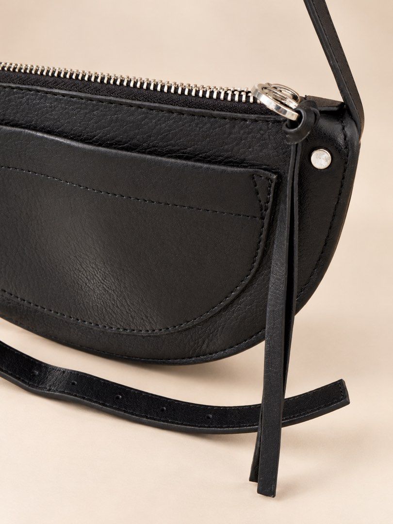 Mango Black Leather Crescent Crossbody Bag (Category: Cross-body Bags) located in Santa Rosa. Submitted by buy888sell (Listing ID 1469611692, Image 2). Description: - Brand: Mango - Material: Bovine leather (genuine) - Hardware: Silver zippers and rings - Features: Front curved slip pocket, fabric lining with branded leather label, top zip closure - Strap: Adjustable with buckle holes - Style: Compact and versatile for everyday use.