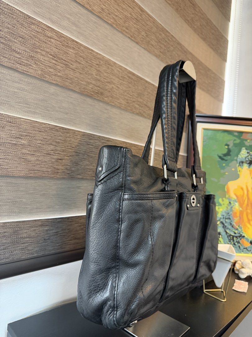 Marc by Marc Jacobs Black Leather Tote Bag (Category: Tote Bags) located in Makati City. Submitted by bagattic_etc (Listing ID 1469620511, Image 3). Description: Brand: Marc by Marc Jacobs Material: Genuine black leather with silver-tone hardware Design: Structured silhouette with multiple exterior pockets and secure turn-lock closure Straps: Comfortable dual shoulder straps Interior: Black and white monogram fabric lining Organization: Features 