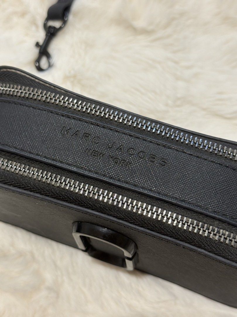 Marc Jacobs Snapshot Crossbody Bag Black (Category: Luxury Bags & Wallets) located in Manila. Submitted by preshyyyyy_ (Listing ID 1469746801, Image 3). Description: - Brand: Marc Jacobs Snapshot Crossbody - Material: Durable black saffiano leather - Hardware: Matte black with signature double J logo - Compartments: Twin zip compartments with fabric lining - Strap: Adjustable and removable thin leather strap - Details: Debossed Marc Jacobs New Yo