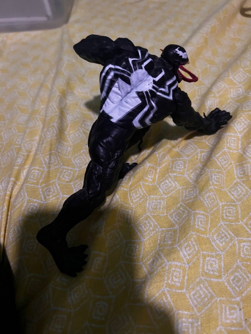 Marvel Venom Action Figure Toy (Category: Figurines & Statues) located in Caloocan City. Submitted by mherckyyragkee (Listing ID 1469675843, Image 2). Description: - Dynamic crouching pose Venom action figure - Detailed black musculature with a textured body - Iconic white spider symbol on the chest - Long, flexible red tongue extending from an open mouth - Articulated limbs for customizable display positions - Perfect collectible for Marvel fans