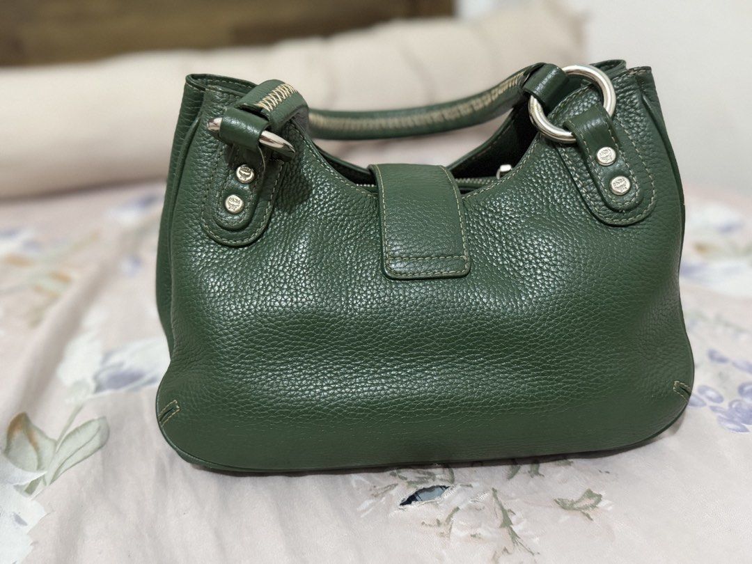 MCM Green Leather Shoulder Bag (Category: Luxury Bags & Wallets) located in Manila. Submitted by maambeeeeyah (Listing ID 1469677101, Image 2). Description: - Brand: MCM - Material: Premium green pebbled leather - Hardware: Silver-tone with metal logo plaque and serial number J8464 - Compartments: Front flap pocket with buckle detail and magnetic closure - Features: Contrast-stitched top handle, protective bottom feet - Condition: Structured shap