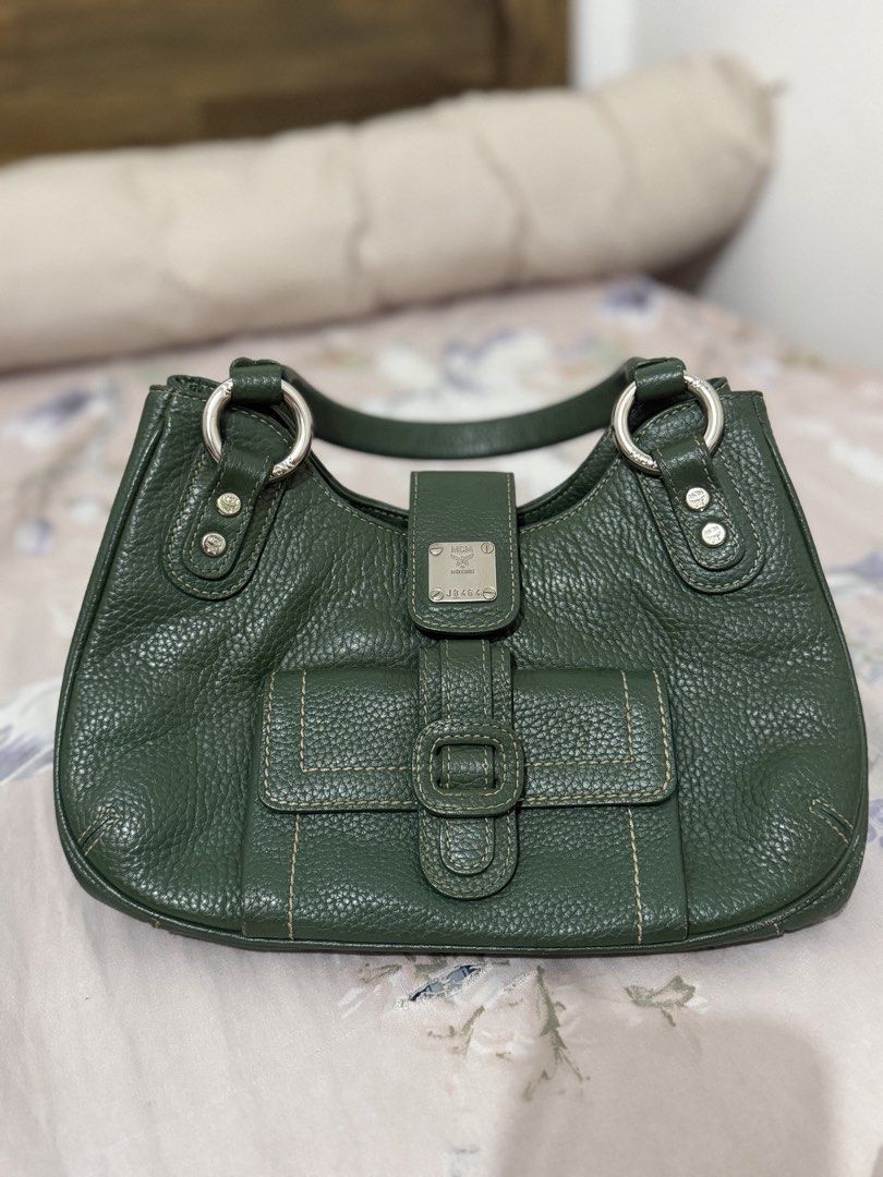MCM Green Leather Shoulder Bag (Category: Luxury Bags & Wallets) located in Manila. Submitted by maambeeeeyah (Listing ID 1469677101, Image 1). Description: - Brand: MCM - Material: Premium green pebbled leather - Hardware: Silver-tone with metal logo plaque and serial number J8464 - Compartments: Front flap pocket with buckle detail and magnetic closure - Features: Contrast-stitched top handle, protective bottom feet - Condition: Structured shap