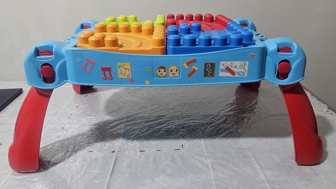MegaBloks Kids Activity Table with Building Blocks and Storage (Category: Lego & Building Sets) located in Quezon City. Submitted by newgem.b5485b (Listing ID 1469587181, Image 1). Description: - Multi-color activity table featuring green, red, blue, and orange top plates - Flip panels to easily store building blocks inside the table body - Built-in side handles for convenient carrying - Foldable red legs make storage quick and simple - Fun decor