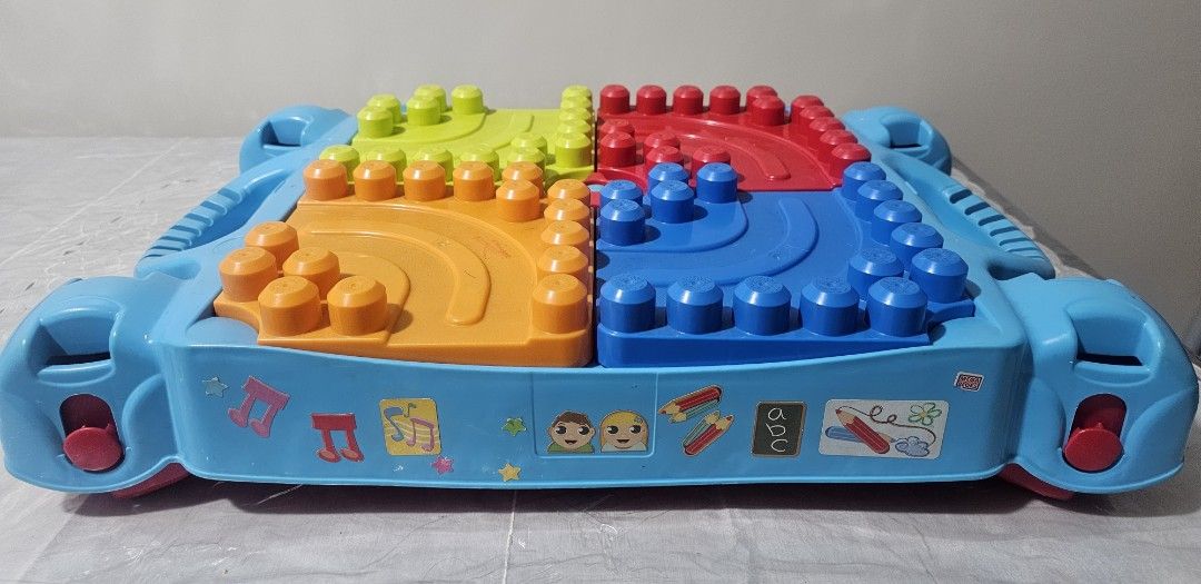 MegaBloks Kids Activity Table with Building Blocks and Storage (Category: Lego & Building Sets) located in Quezon City. Submitted by newgem.b5485b (Listing ID 1469587181, Image 3). Description: - Multi-color activity table featuring green, red, blue, and orange top plates - Flip panels to easily store building blocks inside the table body - Built-in side handles for convenient carrying - Foldable red legs make storage quick and simple - Fun decor