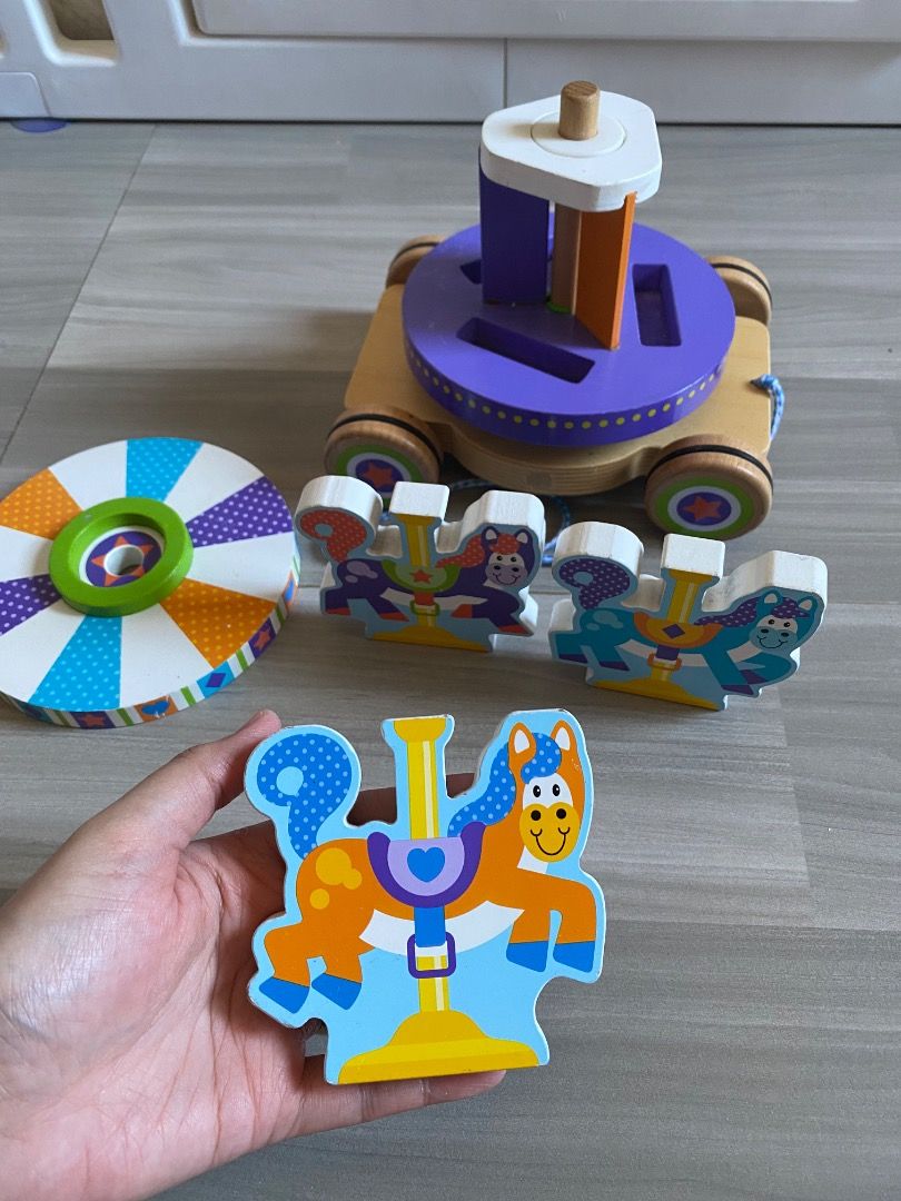Melissa & Doug Carousel Pull toy (RARE) (Category: Kids Toys) located in Bauang. Submitted by tinyhandspreloved (Listing ID 1469594943, Image 3). Description: - Brand: Melissa & Doug First Play - Recommended Age: 18 months and up - Features: Rolling wooden base with pull string, rotating striped top, and purple platform with slots - Activity: Match the 3 colorful horse puzzle pieces into the slots - Benefits: Promotes early motor skills and hand-