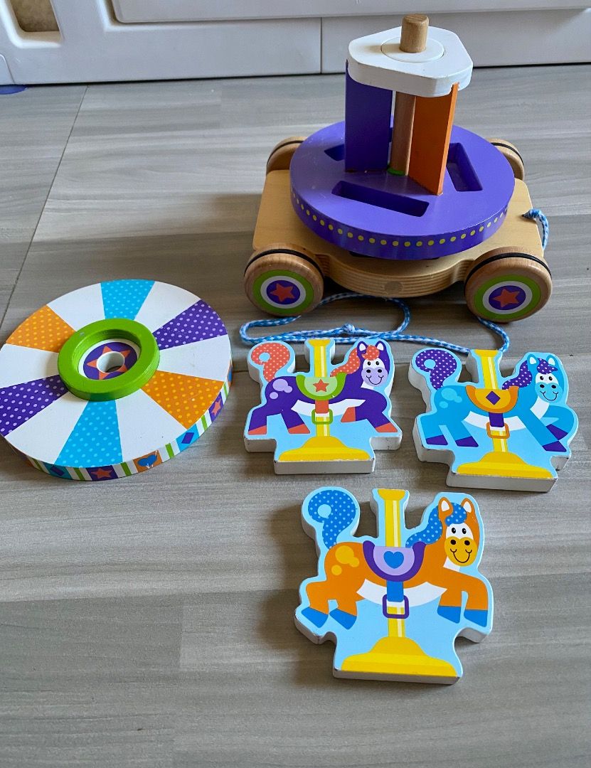 Melissa & Doug Carousel Pull toy (RARE) (Category: Kids Toys) located in Bauang. Submitted by tinyhandspreloved (Listing ID 1469594943, Image 2). Description: - Brand: Melissa & Doug First Play - Recommended Age: 18 months and up - Features: Rolling wooden base with pull string, rotating striped top, and purple platform with slots - Activity: Match the 3 colorful horse puzzle pieces into the slots - Benefits: Promotes early motor skills and hand-