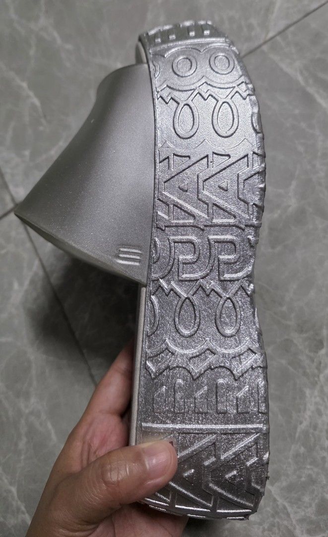 Melissa x Marc Jacobs Platform Slides Silver (Category: Wedges) located in Manila. Submitted by littleclosetfindsmnl (Listing ID 1469694952, Image 3). Description: Melissa x Marc Jacobs Slides – Size 37 -Metallic silver with translucent grey strap -Chunky platform sole with embossed details -Preloved, with signs of use -Flaw: Strap is starting to detach on the side; can be re-glued -Needs cleaning, but overall still good to use -With original box