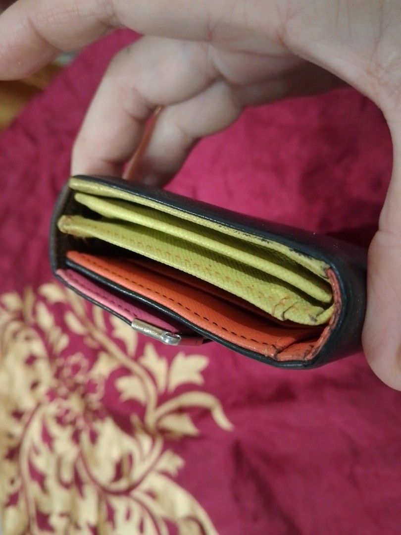 Metrocity Multicolored Long Wallet (Category: Wallets & Card holders) located in Manila. Submitted by annemil_1984 (Listing ID 1469586767, Image 2). Description: Metrocity long wallet in black exterior with vibrant interior compartments in pink, yellow, and orange. Multiple card slots, clear ID window, and snap closure. Metal hardware details on the flap and corners. Interior shows some minor marks on the yellow cardholder section from previous u