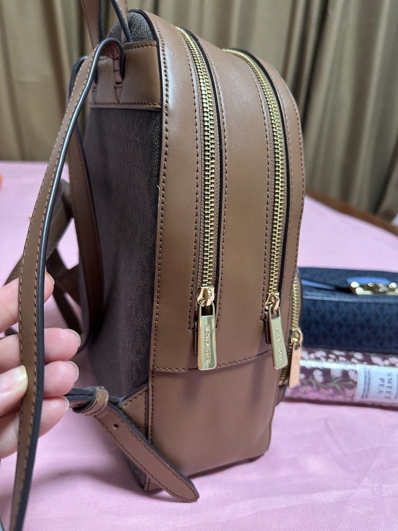 Michael Kors Backpack, Crossbody Bag & Bath & Body Works Mist Bundle (Category: Luxury Bags & Wallets) located in Minalin. Submitted by liatriestosell (Listing ID 1469647467, Image 3). Description: 2+1 bundle SALE (2 MK bag + free BBW mist) - Items for sale: Two Michael Kors bags and one Bath & Body Works mist - Item 1: Brown monogram backpack with brown leather trim, gold-tone zippers, and front pocket - Item 2: Blue and dark grey monogram cross