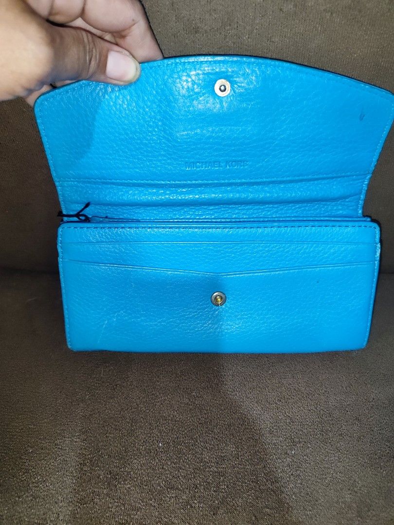 Michael Kors Blue Leather Wallet (Category: Wallets & Card holders) located in Paniqui. Submitted by arlenepari29210 (Listing ID 1469709447, Image 3). Description: - Authentic Michael Kors pebbled leather wallet in a vibrant bright blue - Elegant gold-tone nameplate hardware on the front flap - Secure snap closure leading to multiple card slots, slip pockets, and a zippered coin compartment - Signature MK logo fabric interior lining - Condition: 