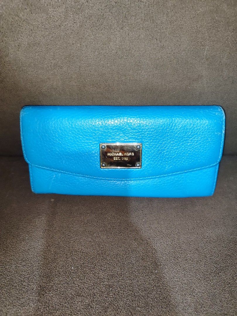Michael Kors Blue Leather Wallet (Category: Wallets & Card holders) located in Paniqui. Submitted by arlenepari29210 (Listing ID 1469709447, Image 1). Description: - Authentic Michael Kors pebbled leather wallet in a vibrant bright blue - Elegant gold-tone nameplate hardware on the front flap - Secure snap closure leading to multiple card slots, slip pockets, and a zippered coin compartment - Signature MK logo fabric interior lining - Condition: 