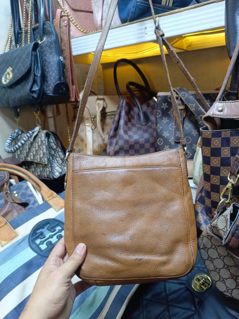 Michael Kors Brown Leather Crossbody Bag (Category: Cross-body Bags) located in Manila. Submitted by dei03_diz (Listing ID 1469641772, Image 3). Description: - Authentic Michael Kors brown leather crossbody bag - Features a functional front flap with a sleek metal padlock closure - Adjustable shoulder strap for a comfortable, custom fit - Signature fabric interior lining with a branded leather patch - Compact everyday size with a trendy, slouchy 
