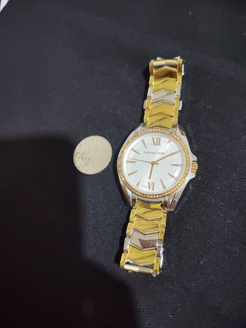 Michael Kors Two-Tone Chevron Bracelet Watch (Category: Women's Watches) located in San Pablo. Submitted by leogirlshel (Listing ID 1469642762, Image 1). Description: Michael Kors watch with a round white dial, Roman numerals at twelve and six, and crystal markers around the bezel. Two-tone gold and silver chevron link bracelet with a fold-over clasp engraved with the Michael Kors logo. Shows minor surface wear on the metal links from regular use