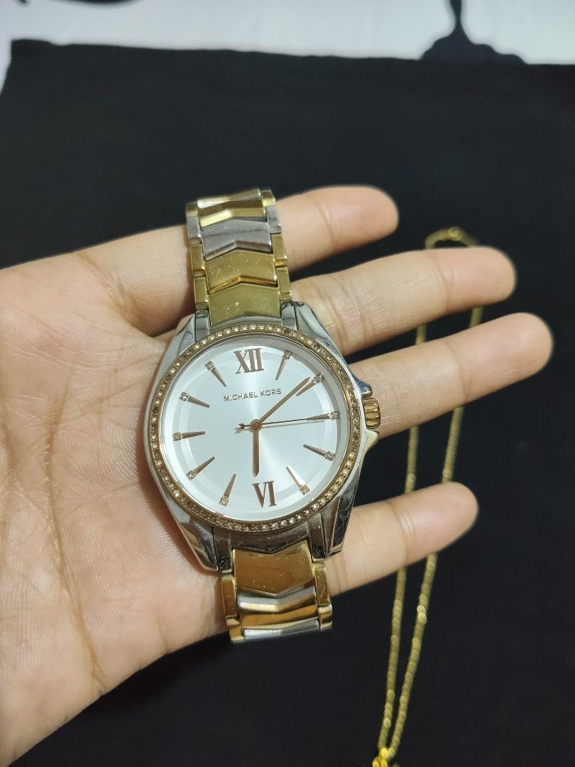 Michael Kors Two-Tone Chevron Bracelet Watch (Category: Women's Watches) located in San Pablo. Submitted by leogirlshel (Listing ID 1469642762, Image 2). Description: Michael Kors watch with a round white dial, Roman numerals at twelve and six, and crystal markers around the bezel. Two-tone gold and silver chevron link bracelet with a fold-over clasp engraved with the Michael Kors logo. Shows minor surface wear on the metal links from regular use